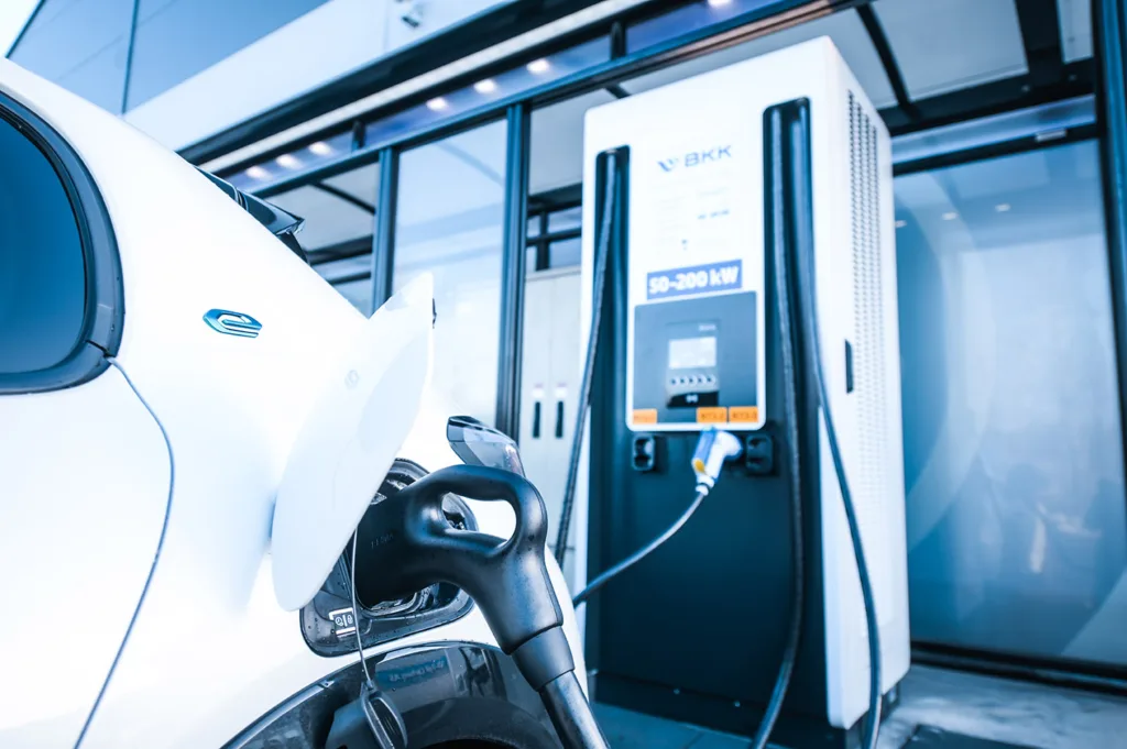 Samochód elektryczny podłączony do stacji ładowania z wyświetlaczem