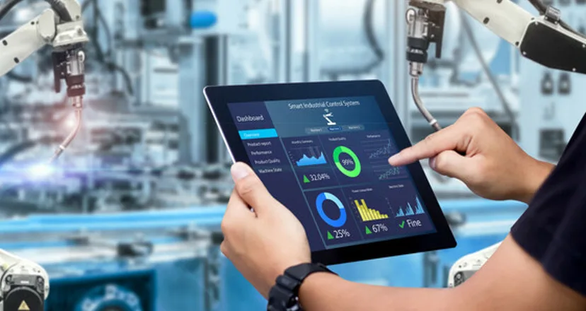 Inżynier z tabletem z danymi produkcyjnymi w fabryce z robotami