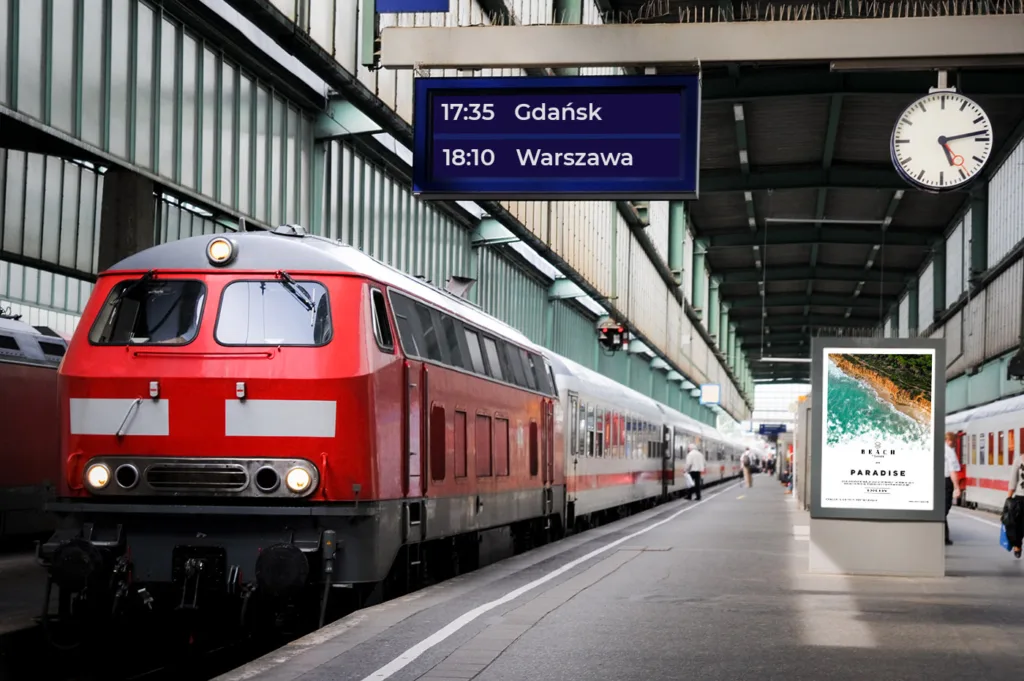 Peron kolejowy z tablicą odjazdów i cyfrowym ekranem informacyjnym